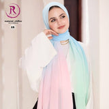 A woman wearing a lightweight chiffon hijab with a pastel gradient transition from light blue to pink, peach, and mint green. She is also wearing a white blouse and black pants, standing against a soft beige background with promotional text overlays.