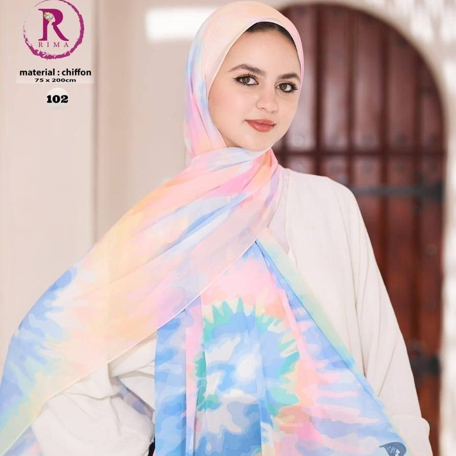 A woman wearing a pastel tie-dye chiffon hijab with pink, blue, yellow, and green patterns, paired with a white long-sleeve top. The image features branding and social media details for 'Rim' on the left and bottom.