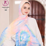 A woman wearing a pastel tie-dye chiffon hijab with pink, blue, yellow, and green patterns, paired with a white long-sleeve top. The image features branding and social media details for 'Rim' on the left and bottom.